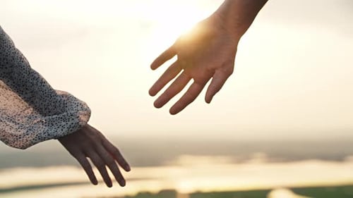 Close Up of Hands Meeting Over Landscape