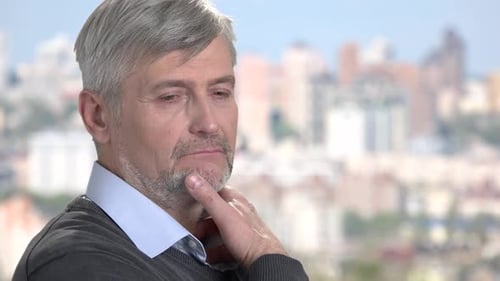 Thoughtful Man Gazing at a Blurred Cityscape