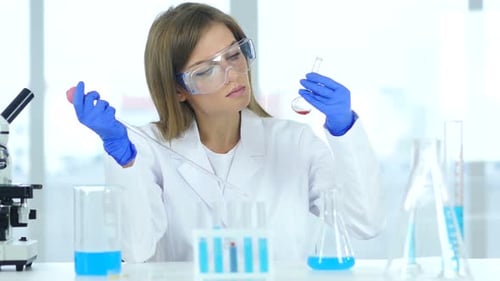 Woman Scientist Working in Laboratory with Pipette