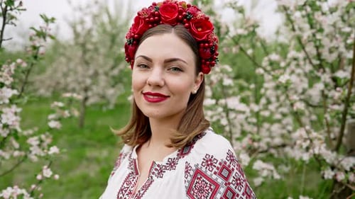 Young Pretty Woman in Traditional Festive Vyshyvanka Dress in Blossom Garden