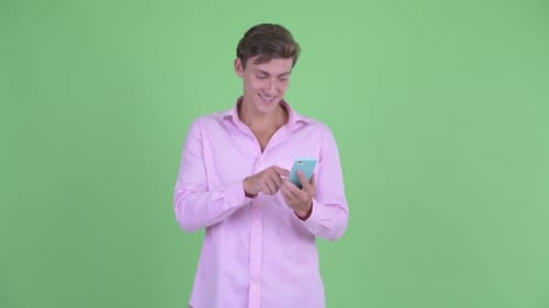 Man Smiles While Using Smartphone