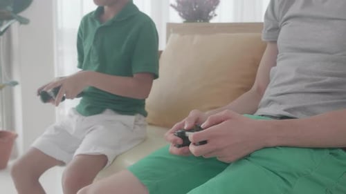 Child and Adult Playing Video Games on Couch