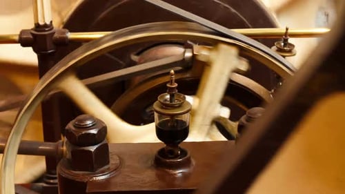 Closeup view of a flywheel of a single cylinder industrial steam engine in operation