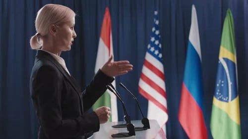 Woman Speaking at Podium with Flags
