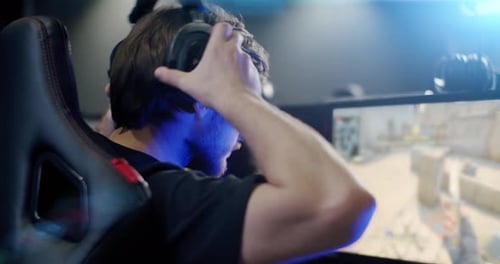 the Gamer Plays an Online Video Game, and Comments Into the Microphone , Close Up