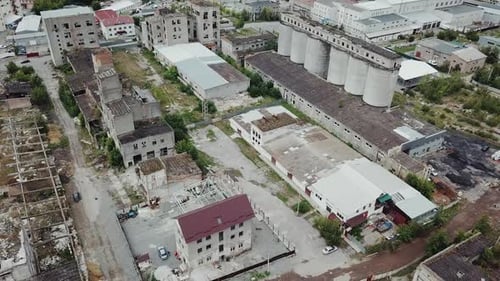 Flying over abandoned industrial factory buildings in very dilapidated condition.