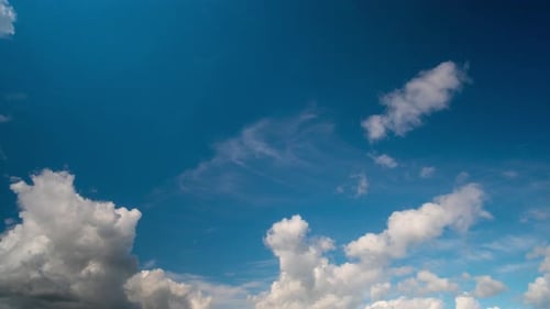 Fluffy White Clouds Float in Deep Blue Sky