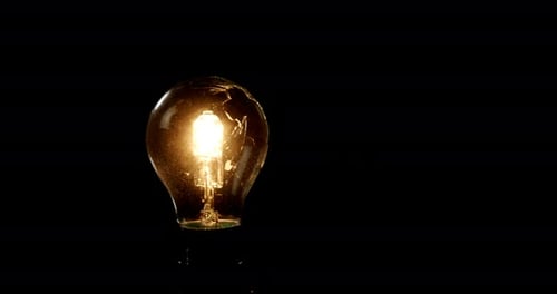 Illuminated ;light bulb against black background 4k