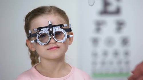 Ophthalmologist Changing Lens in Eye Testing Glasses to Diagnose Child Vision