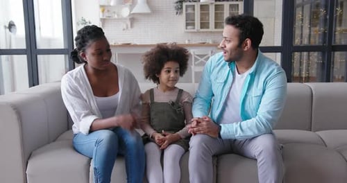 Happy Family Talking on a Couch Indoors