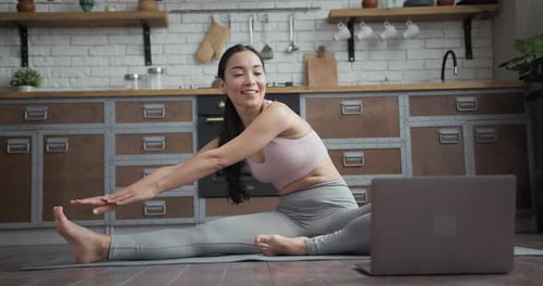 Woman Stretching Legs in Kitchen on Yoga Mat