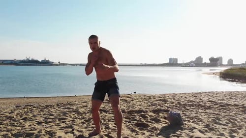 Shirtless Man Doing Front Kicks on Beach