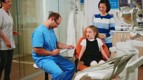 Nurse Taking Notes on Clipboard About Little Girl Dental Problems