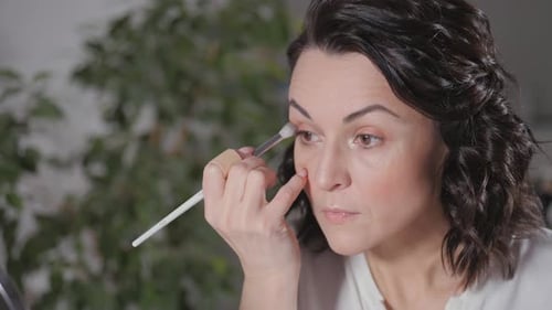 Woman Applying Eye Shadow with Makeup Brush