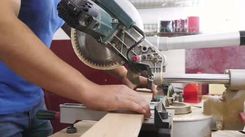 Carpenter cutting wood with a circular saw