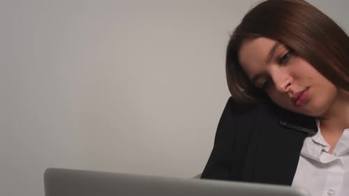 Woman Talking on Phone at Laptop Close Up
