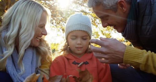Family Laughing Together Outdoors with Autumn Leaves