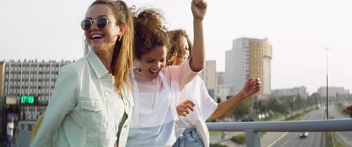 Friends Dancing on Bridge in City