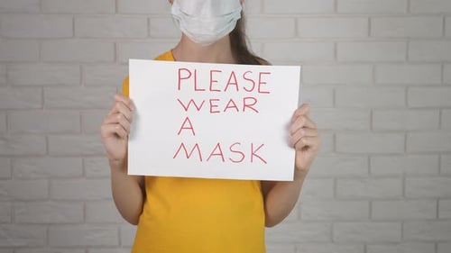 Girl Wearing Mask and Holding Sign