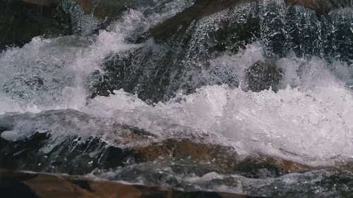 Mountain Creek and Stone Rapids with Snow. Rapid Flow of Water. Winter Waterfall. Slow Motion