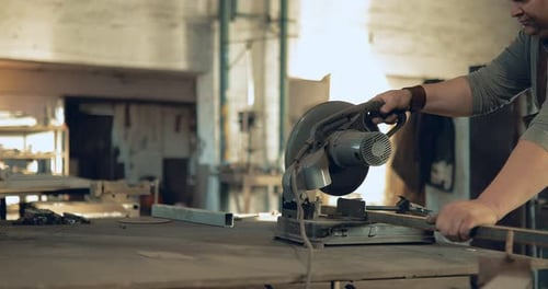 Man Using Metal Cutting Saw in Workplace