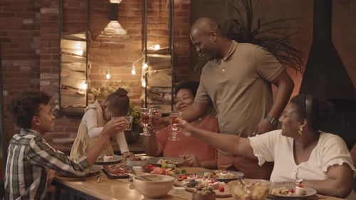 Family Toasting Drinks Together at a Dinner Table