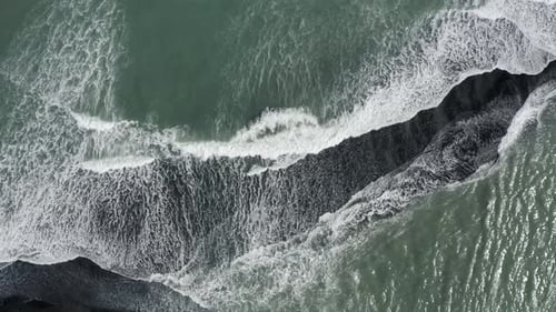 Top Down View Of Foamy Ocean Waves On Reynisfjara Beach In Iceland - drone shot
