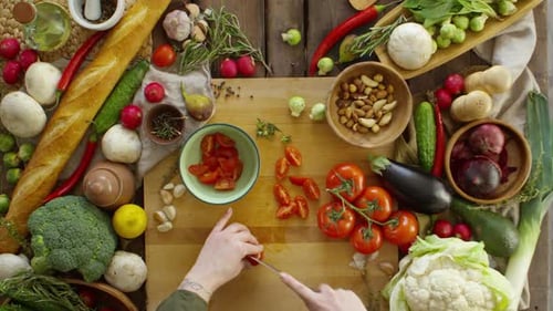 Tomatoes Being Sliced on Cutting Board with Food