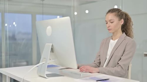 Ernsthafte junge Geschäftsfrau arbeitet im Büro auf dem Schreibtisch