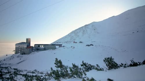 ski Centre on top of snow covered mountain peak accessed by cableway, static shot