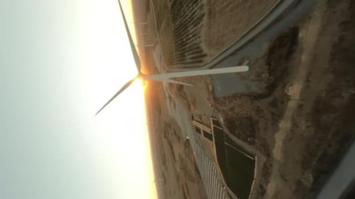 Vertical Dynamic Fpv Shot of White Operative Wind Turbine While Beautiful Sunset