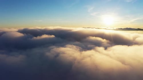 Soleil brillant au-dessus des nuages blancs duveteux au lever du soleil