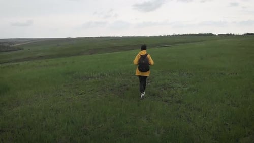 Person Walking in a Rural Field on Overcast Day