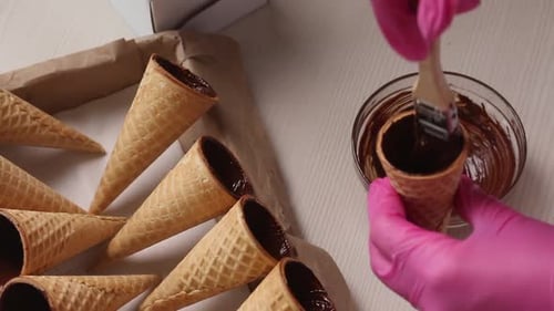 Chocolate Being Brushed Into Ice Cream Cones