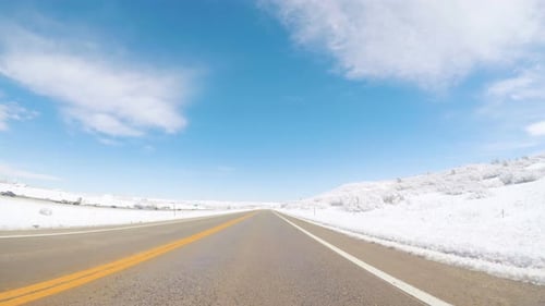 Scenic Drive on Snowy Road on Sunny Day