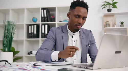 Young Adult Typing on Laptop in Bright Office