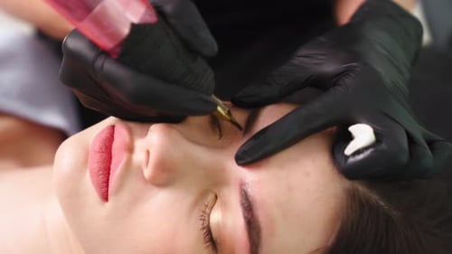 Woman Getting Eyebrow Tattoo in Beauty Salon