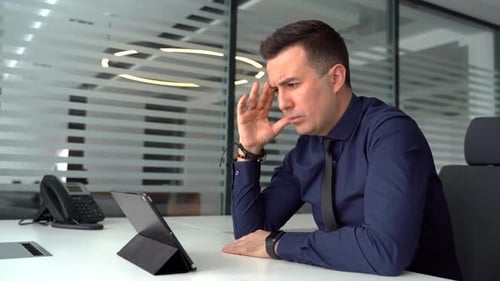 Focused Young Businessman Holding Video Call with Clients on Laptop in Moder Office