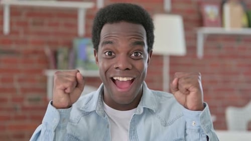 Excited Young Adult Celebrating Success Indoors