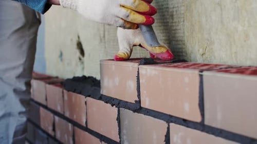 bricklayer lays bricks, exterior wall