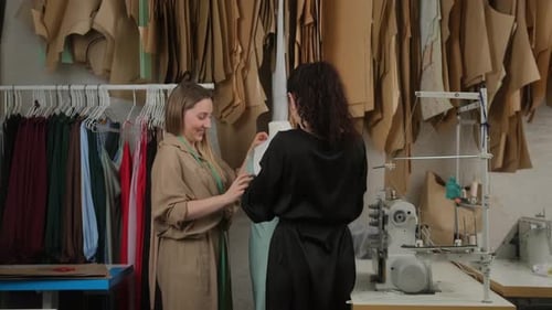 Zwei professionelle Schneider, Designer oder Näherinnen, die mit einem neuen Modell arbeiten, um ein Schneiderkleid zu entwerfen