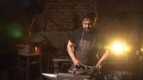 Skilled Blacksmith Shaping Metal in Workshop