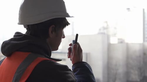 Der Bauingenieur leitet den Bauprozess und gibt den Befehl per Funk-Walkie-Talkie.
