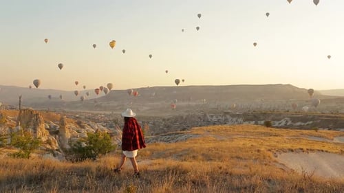 Woman Walks Among Hot Air Balloons in Cappadocia