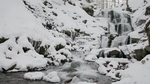 Wonderful Frozen Foot of a Waterfall with a Powerful Stream of Water at Winter Carpathian Mountains