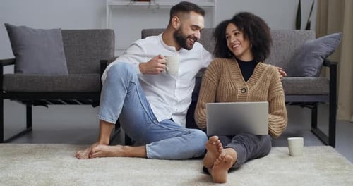 Couple Relaxing at Home with Laptop