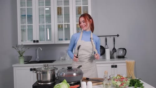 Happy Woman Dancing While Cooking in Kitchen
