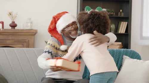 Child Gives Christmas Gift to Adult, Embracing with Love