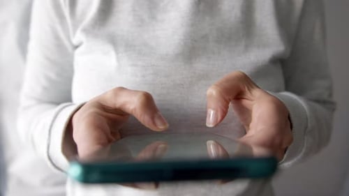 Woman Typing On Cell Phone With Both Hands
