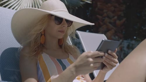 Fashionable Woman Lounging With Tablet Outdoors